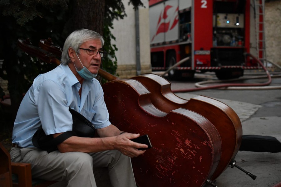 Imaginea neputinței: Dirijorul Petre Neamțu păzind instrumentele salvate din flăcările care au mistuit Filarmonica Națională din Chișinău